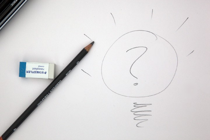 eraser and pencil next to a sketch of a question mark