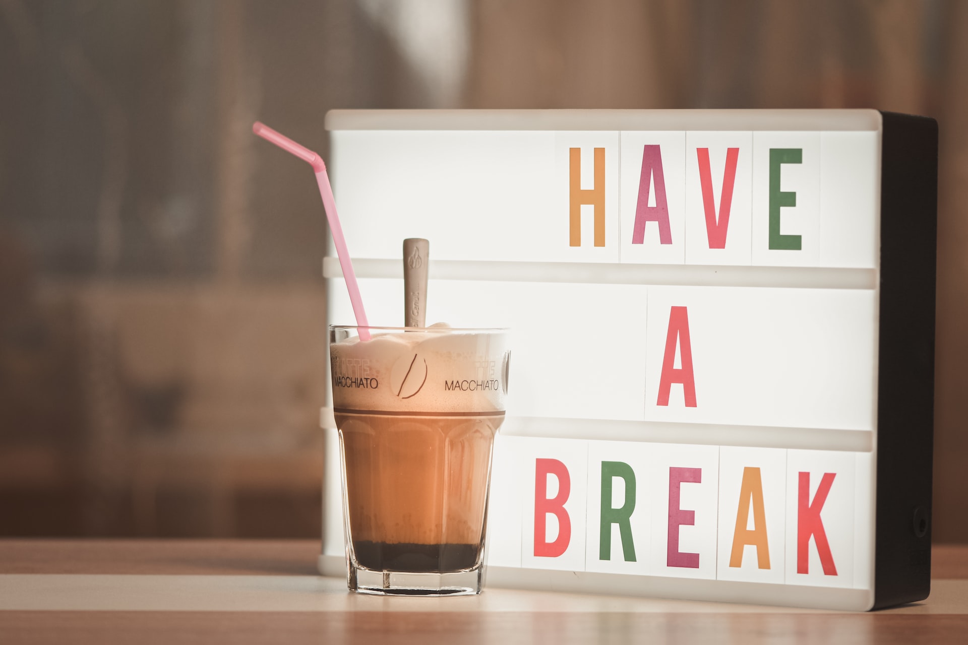 An iced-coffee in front of a have a break sign